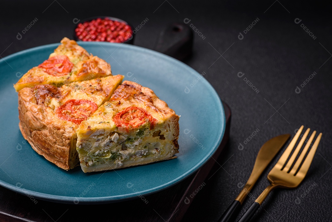 Deliciosa quiche com tomate, queijo, frango, especiarias e ervas sobre um fundo escuro de concreto