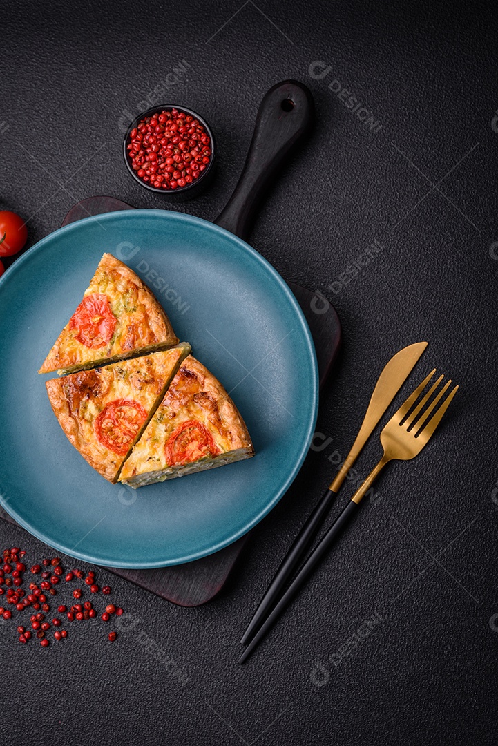 Deliciosa quiche com tomate, queijo, frango, especiarias e ervas sobre um fundo escuro de concreto