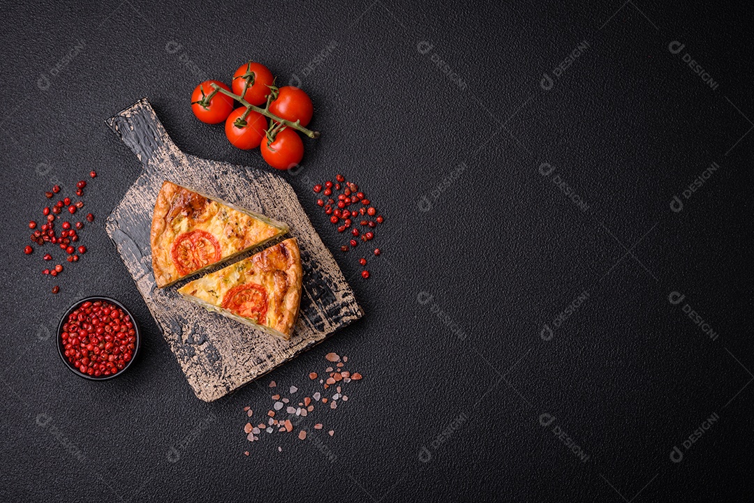 Deliciosa quiche com tomate, queijo, frango, especiarias e ervas sobre um fundo escuro de concreto