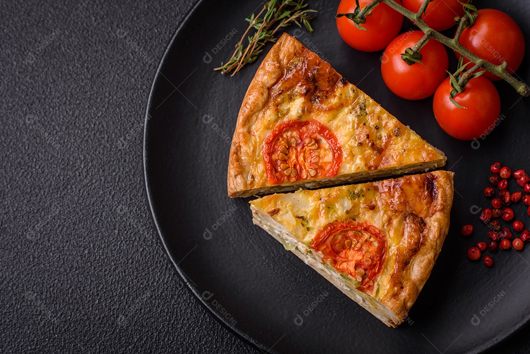Deliciosa quiche com tomate, queijo, frango, especiarias e ervas sobre um fundo escuro de concreto