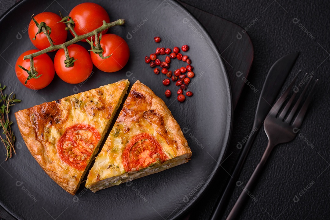 Deliciosa quiche com tomate, queijo, frango, especiarias e ervas sobre um fundo escuro de concreto