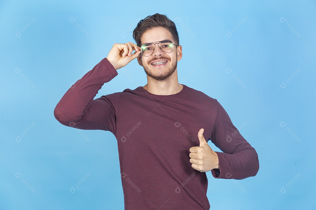Homem usando óculos sobre um fundo isolado azul.