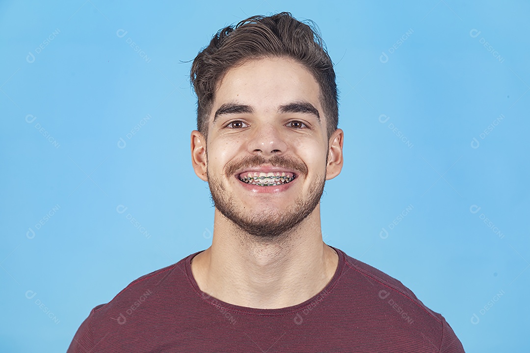 Homem jovem sorridente sobre fundo isolado azul.