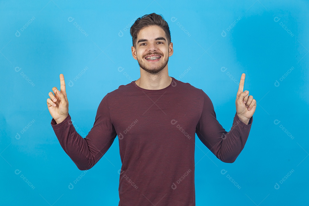 Homem sorridente apontando para cima sobre fundo isolado azul.