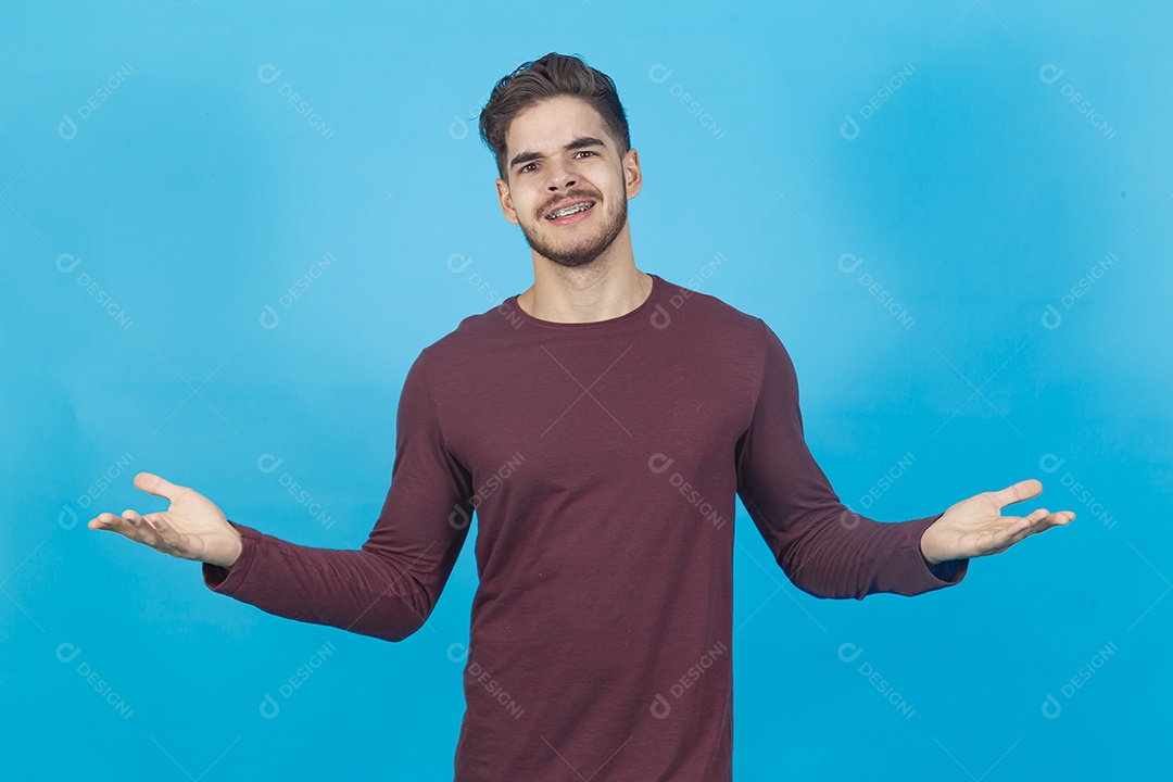 Homem sorridente de braços abertos sobre fundo isolado azul.