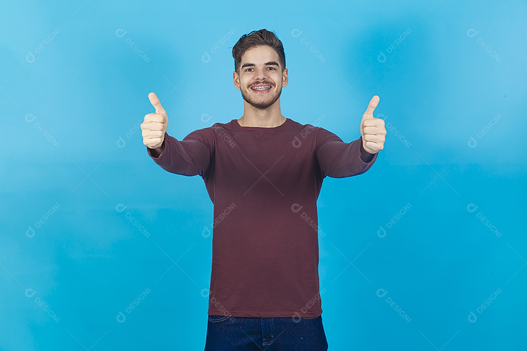Homem de camisa manga longa sobre fundo isolado azul.