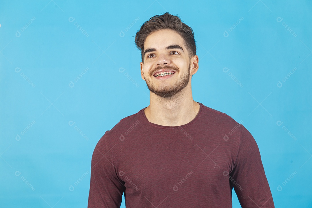 Homem jovem sorridente sobre fundo isolado azul