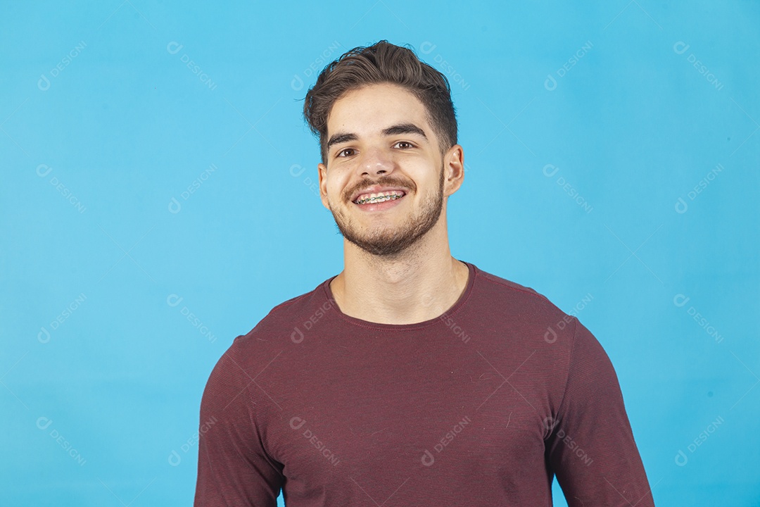 Homem jovem sorridente sobre fundo isolado azul
