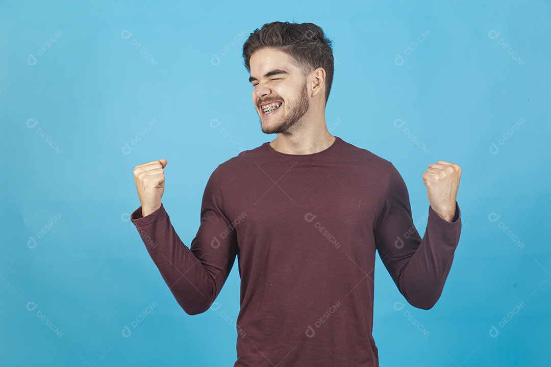 Homem jovem comemorando sobre fundo isolado azul