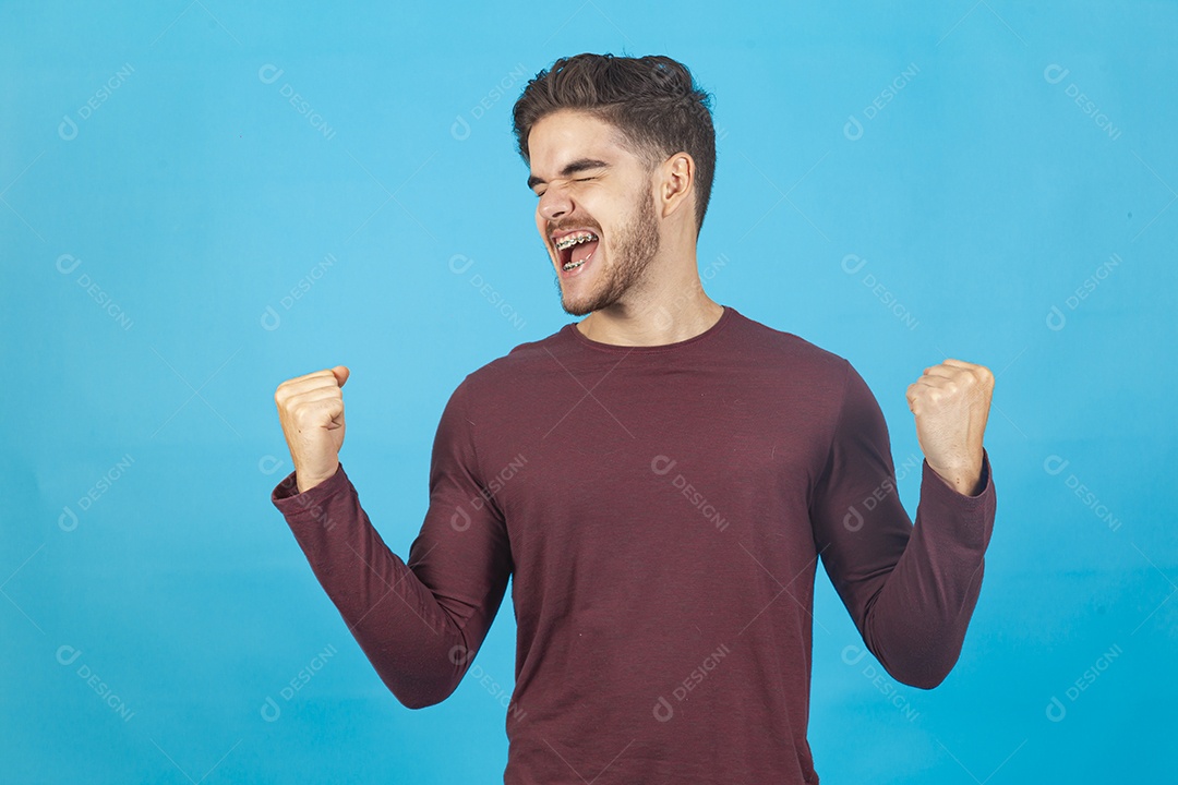 Homem jovem comemorando sobre fundo isolado azul