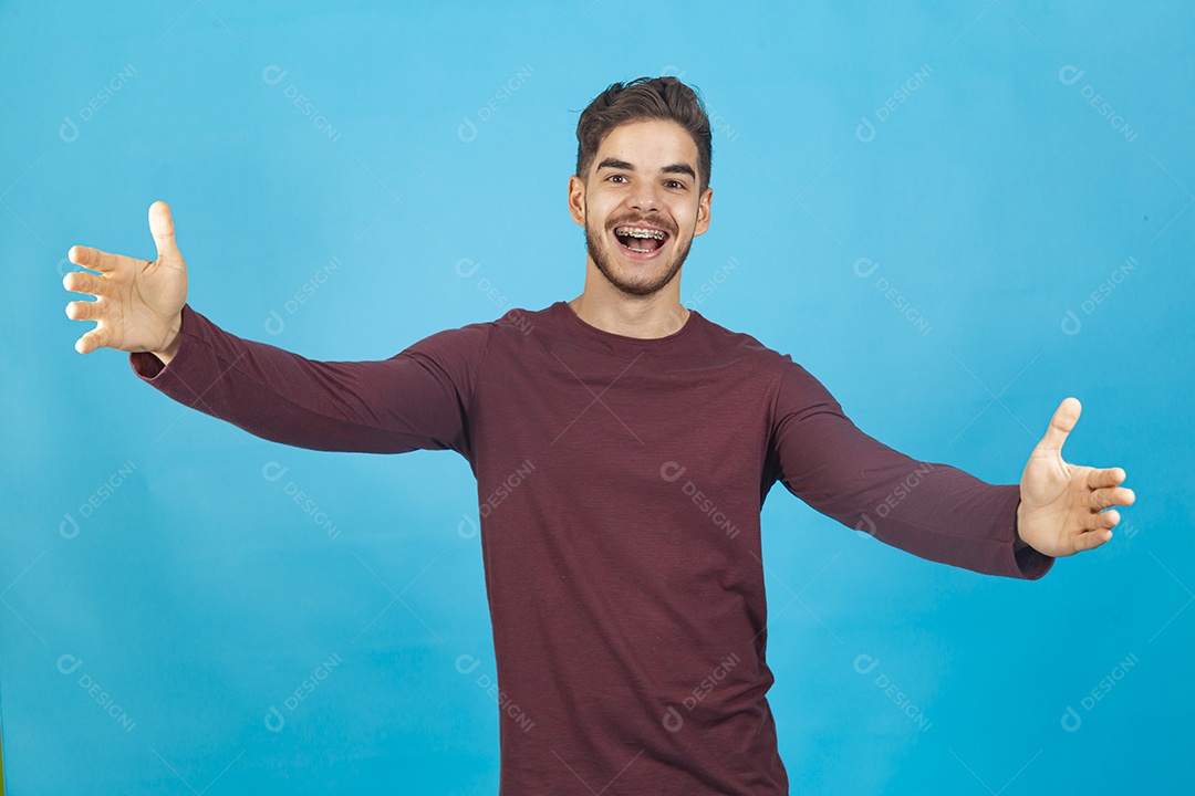 Homem jovem sorridente sobre fundo isolado azul