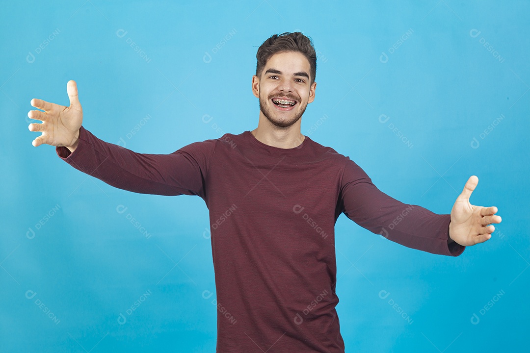 Homem jovem sorridente sobre fundo isolado azul