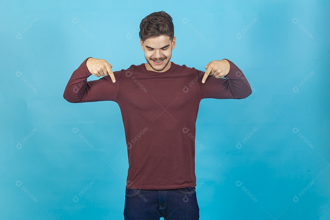 Homem de camisa manga longa sobre fundo isolado azul.