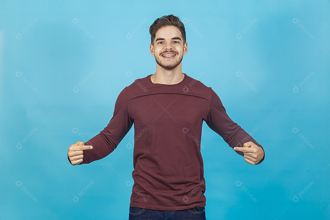 Homem sorridente apontando para si mesmo sobre fundo isolado azul.
