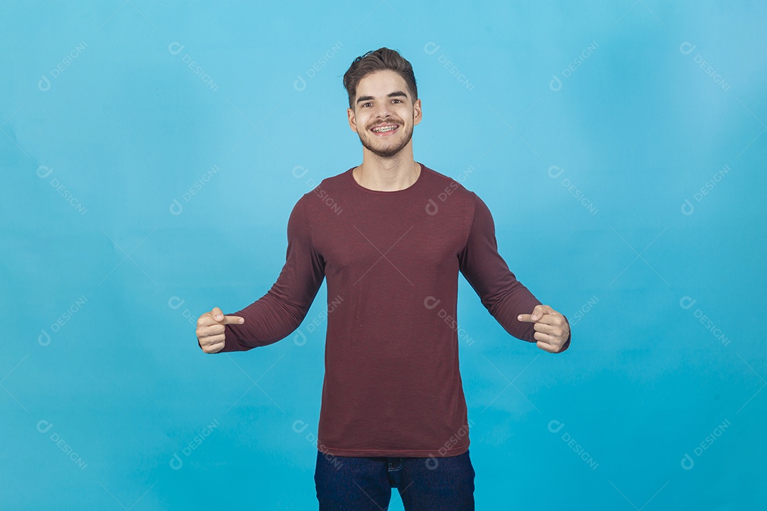 Homem sorridente apontando para si mesmo sobre fundo isolado azul.