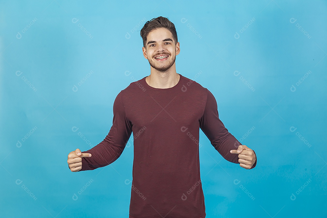 Homem sorridente apontando para si mesmo sobre fundo isolado azul.