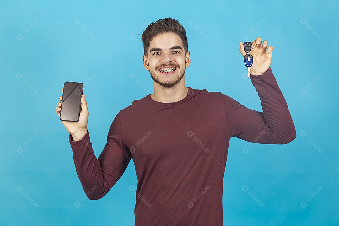 Homem sorridente segurando celular sobre um fundo isolado azul.