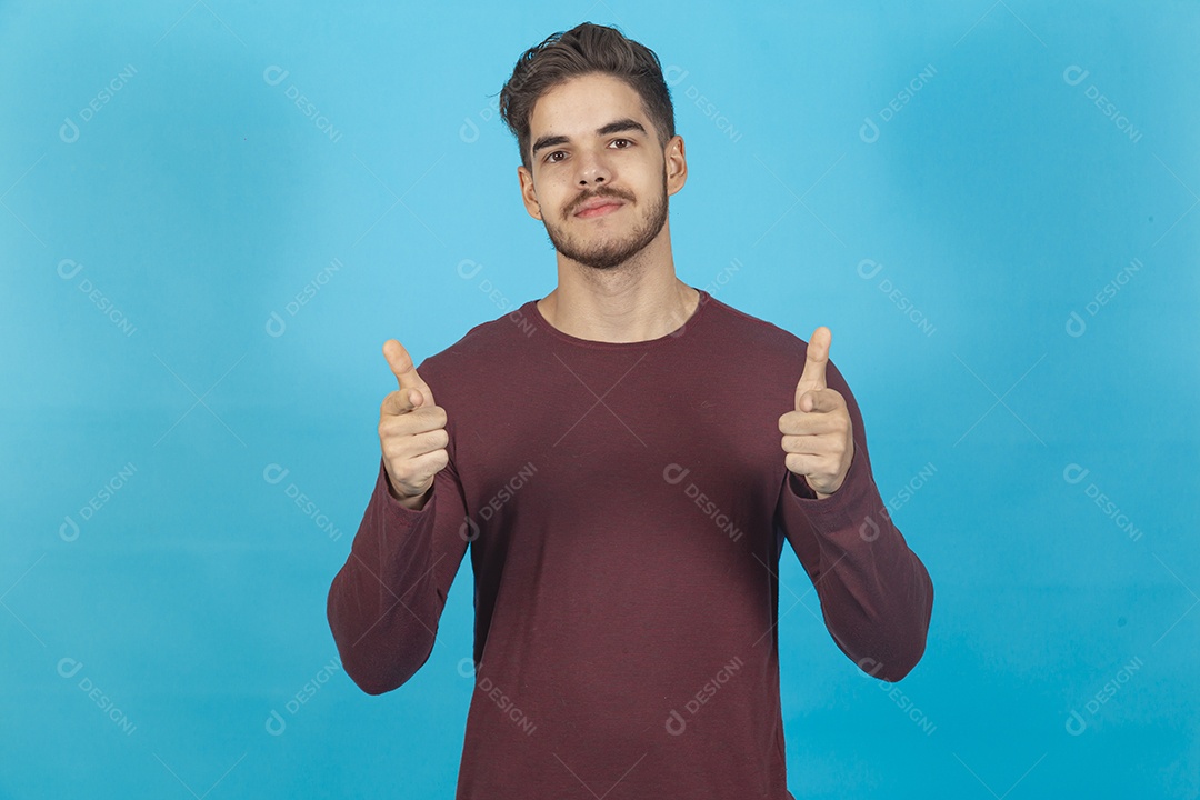 Homem fazendo sinal positivo sobre fundo isolado azul.