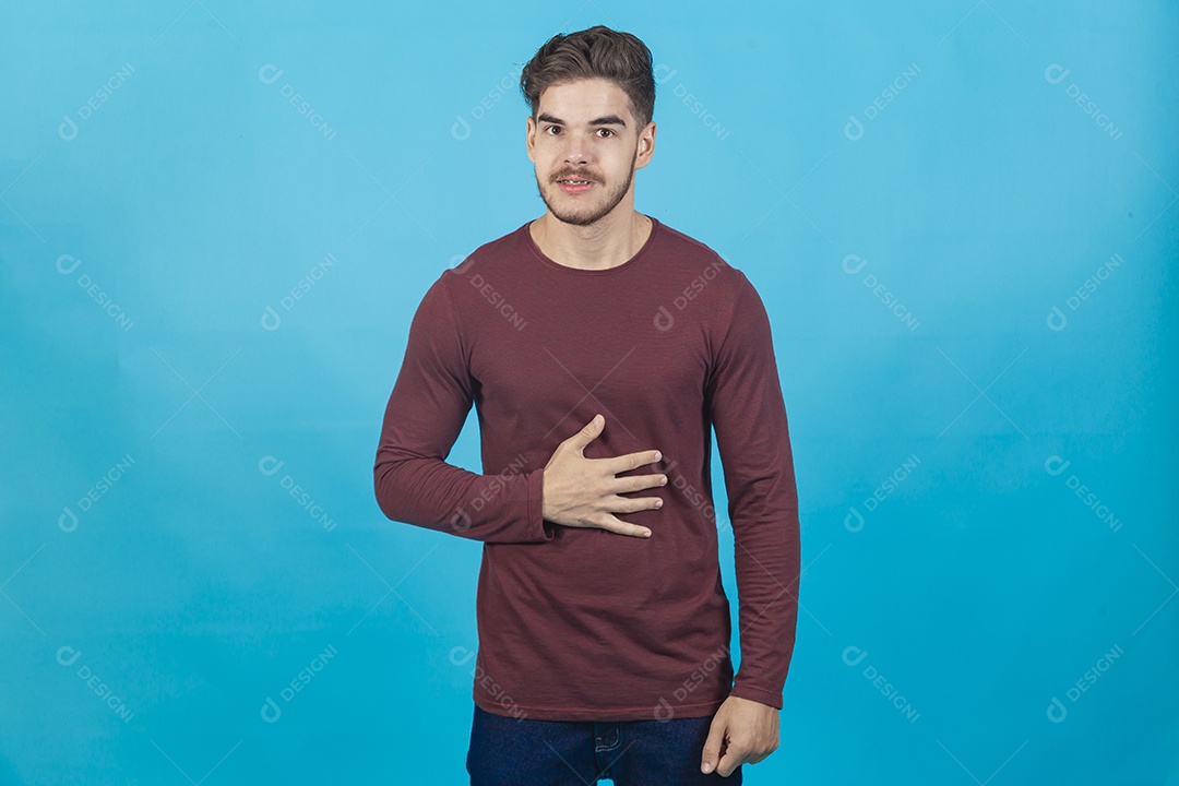 Homem com a mão no abdome sobre fundo isolado azul.