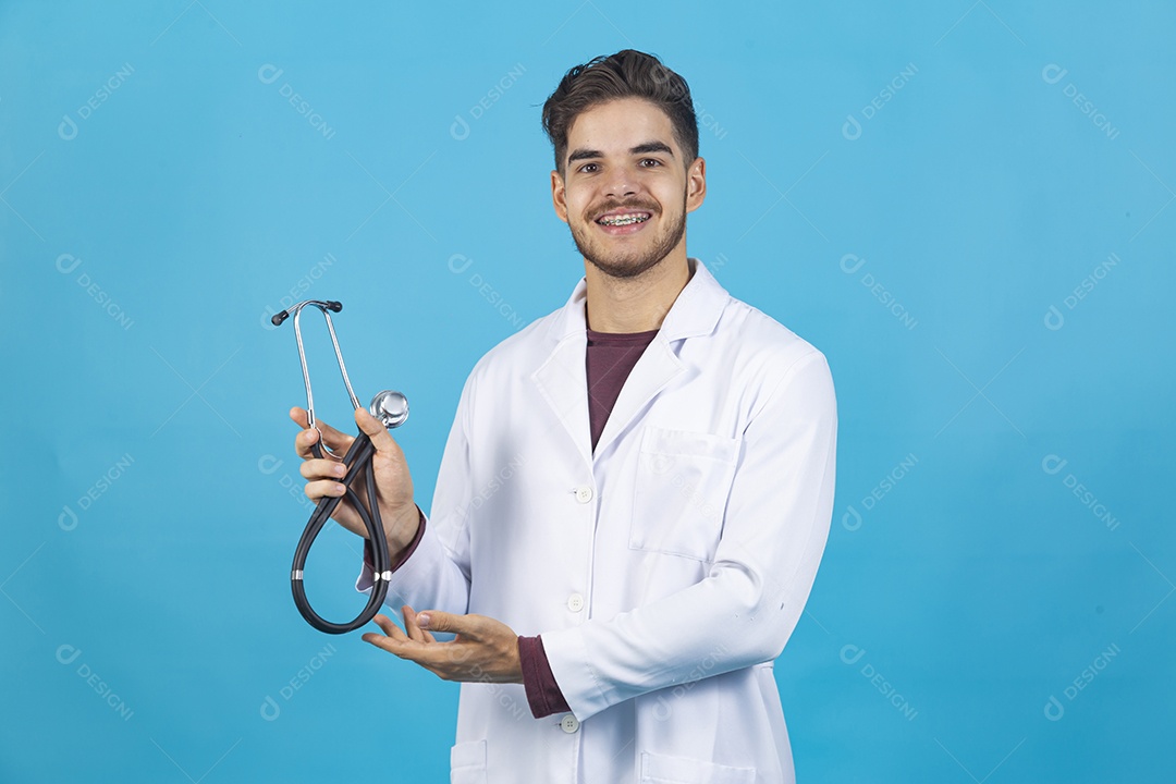 Homem jovem usando jaleco segurando estetoscópio.