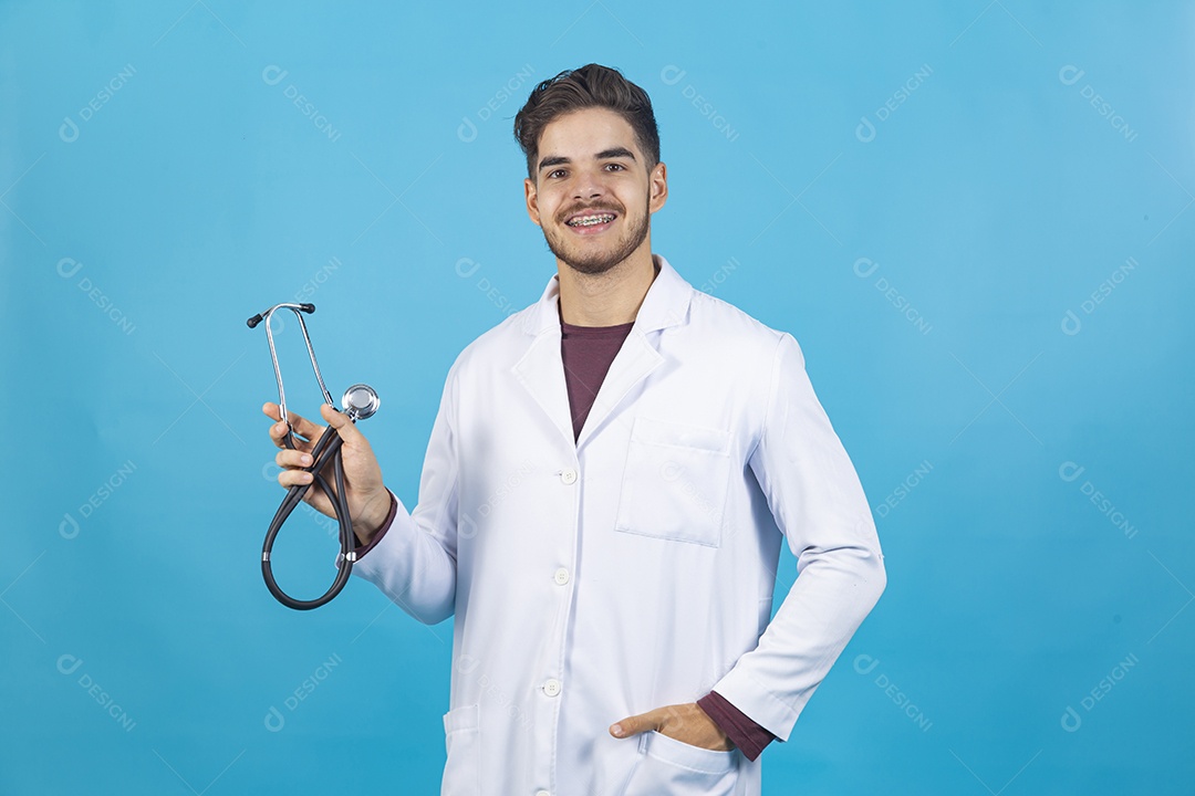 Homem jovem usando jaleco segurando estetoscópio.