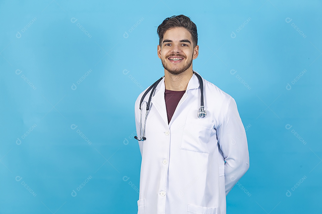 Homem jovem usando jaleco segurando estetoscópio.