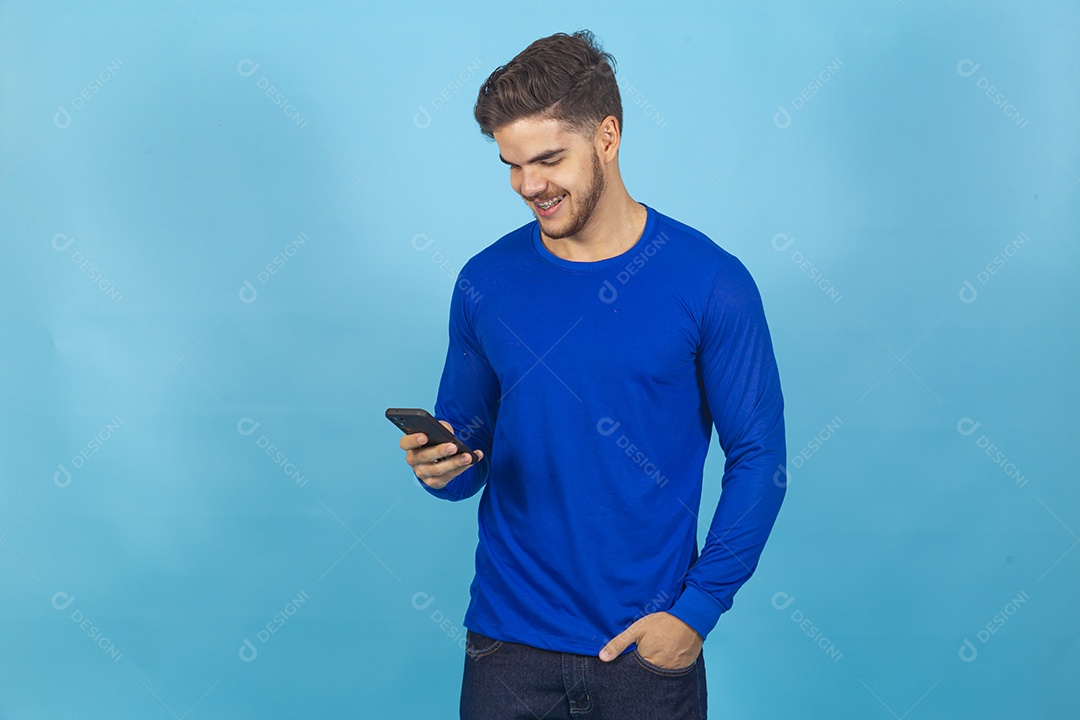 Homem de camisa manga longa sobre fundo isolado azul.