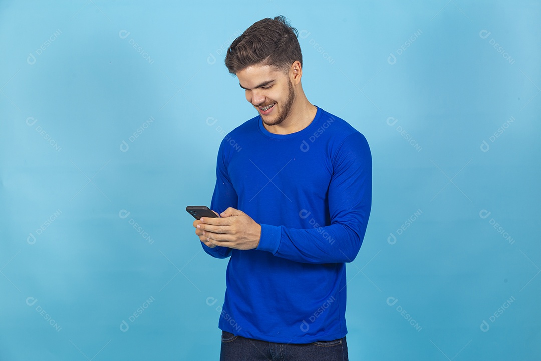 Homem de camisa manga longa segurando celular.