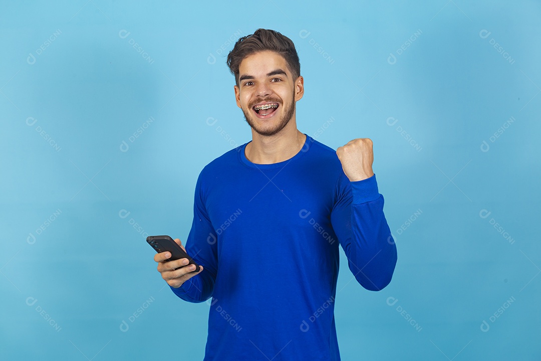 Homem de camisa manga longa segurando celular.