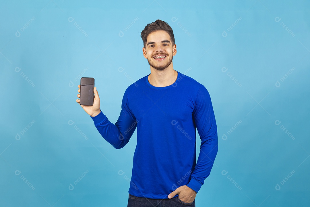 Homem de camisa manga longa segurando celular.
