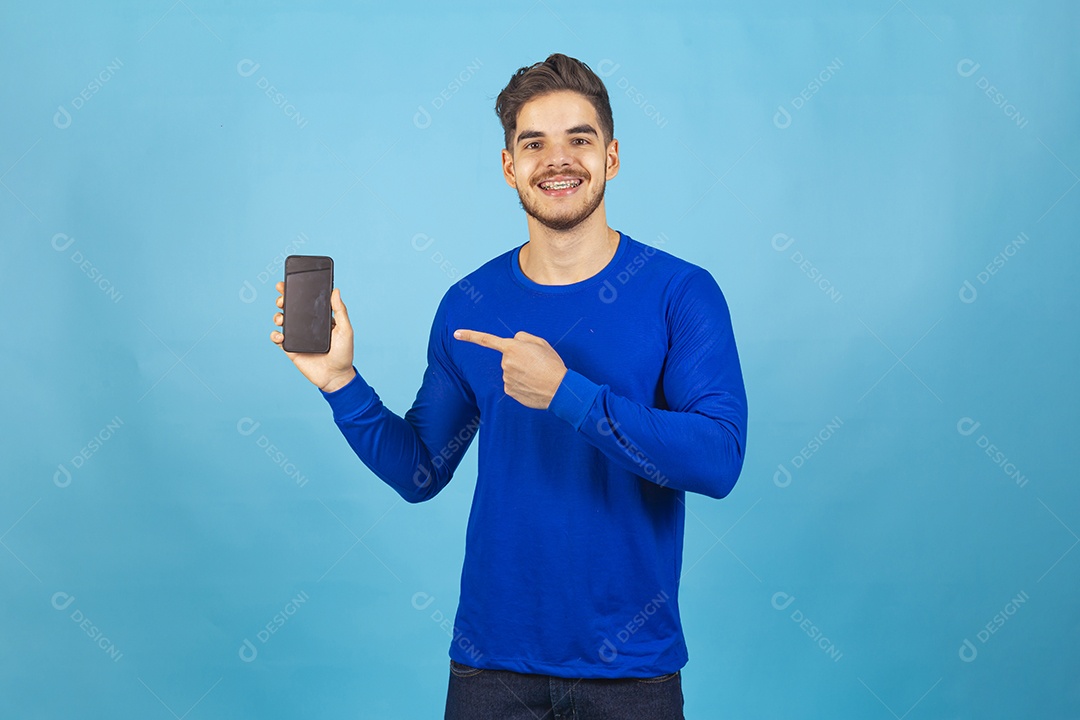 Homem de camisa manga longa segurando celular.