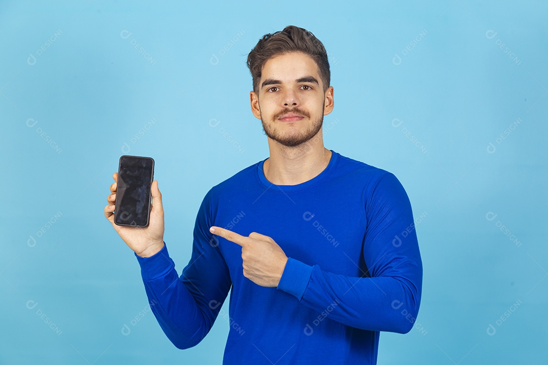 Homem segurando celular sobre um fundo isolado azul.