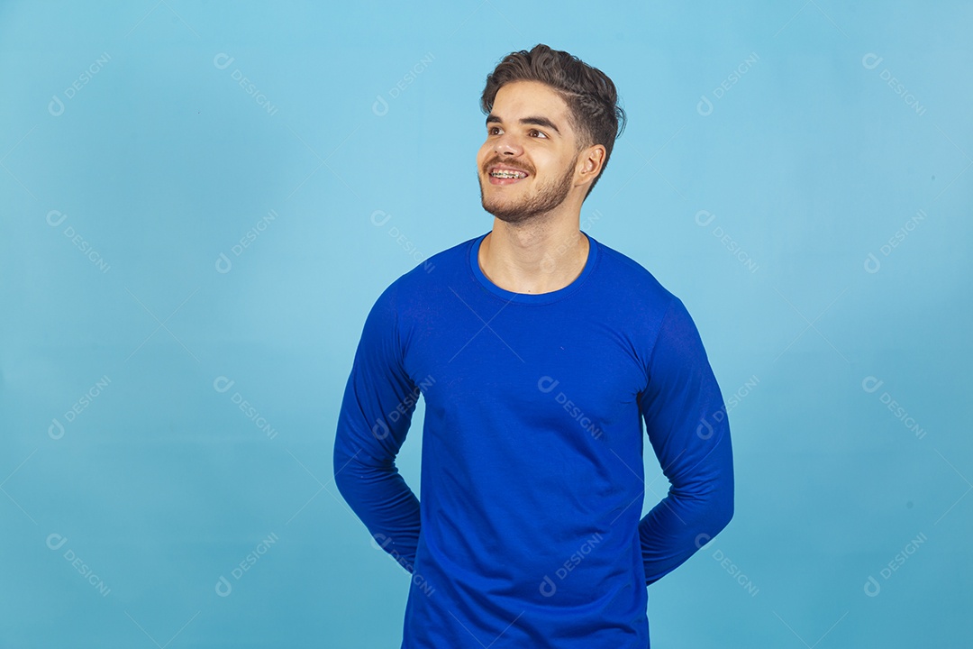 Homem sorridente vestido de camiseta manga longa azul.