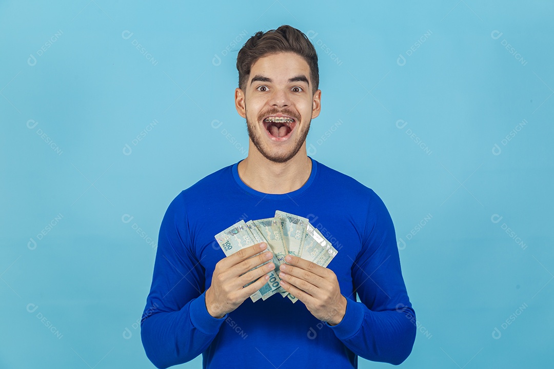 Homem jovem e feliz com cédulas em mãos.