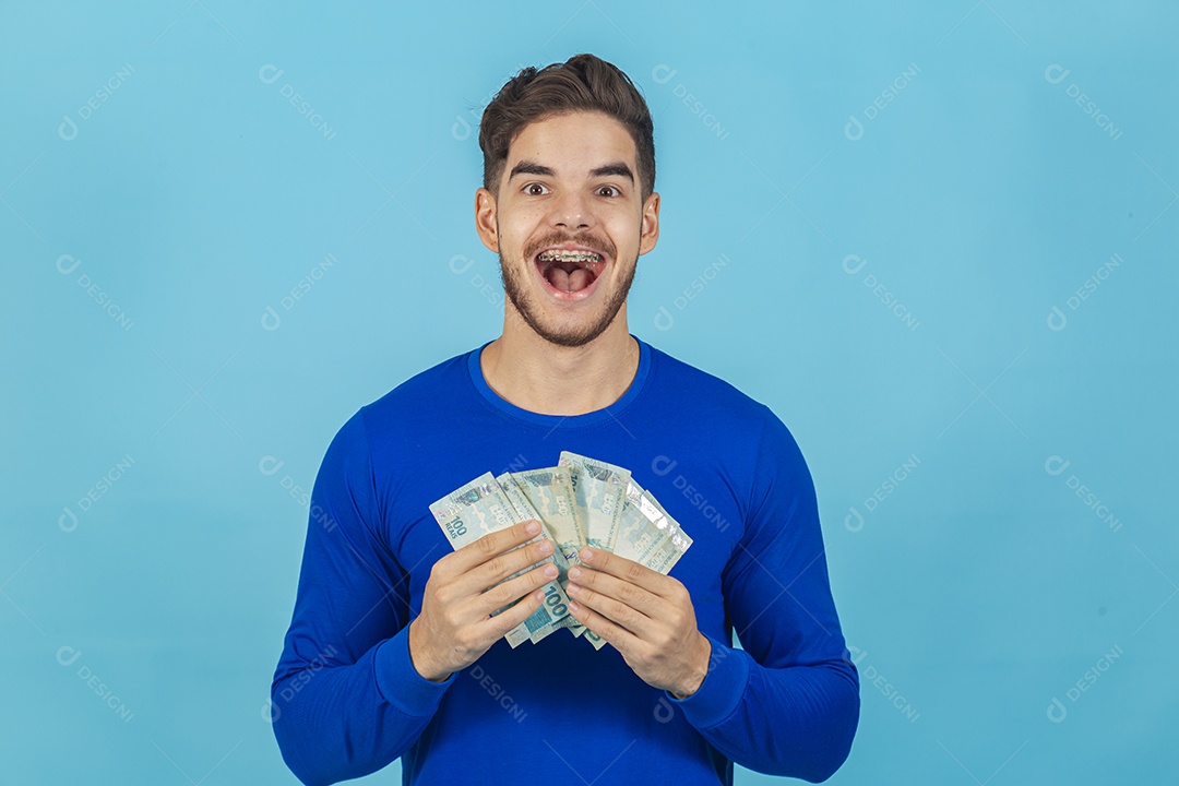 Homem jovem e feliz com cédulas em mãos.