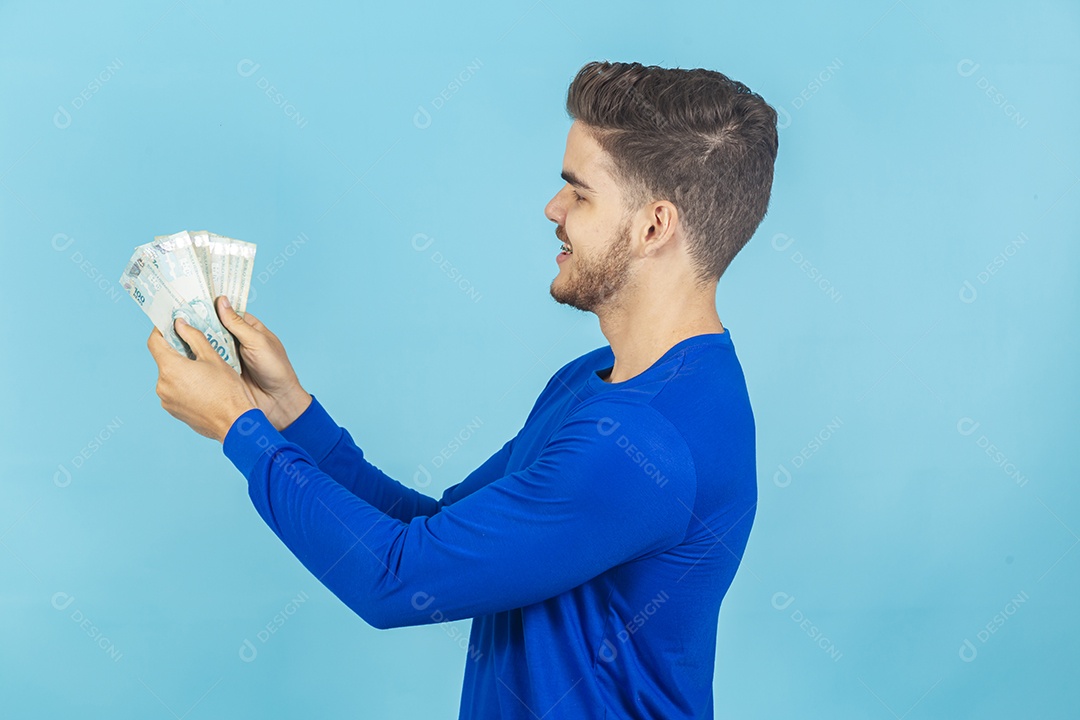 Homem jovem e feliz com cédulas em mãos.