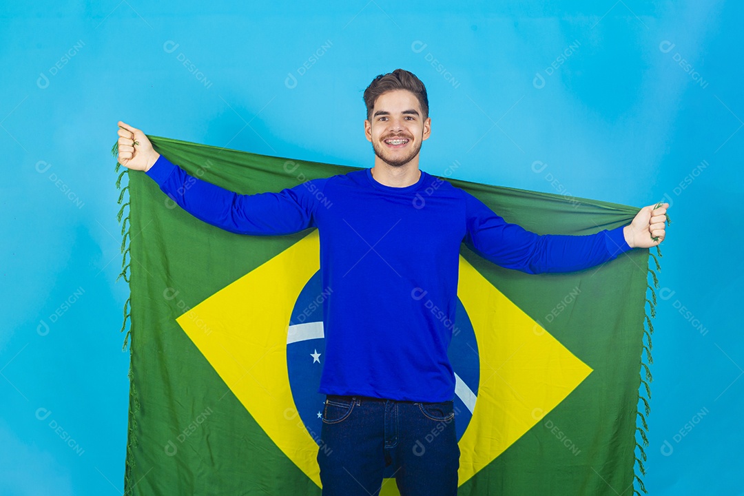 Homem segurando bandeira do Brasil sobre um fundo isolado azul.
