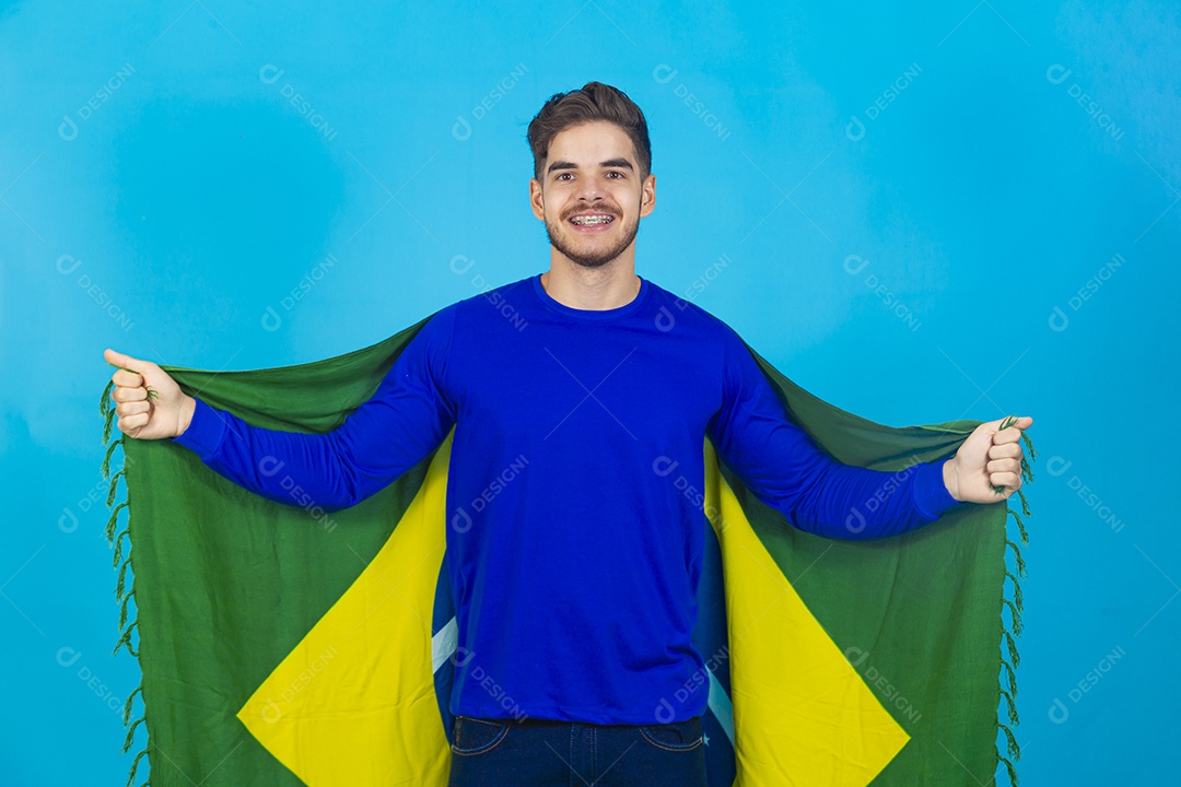 Homem segurando bandeira do Brasil sobre um fundo isolado azul.