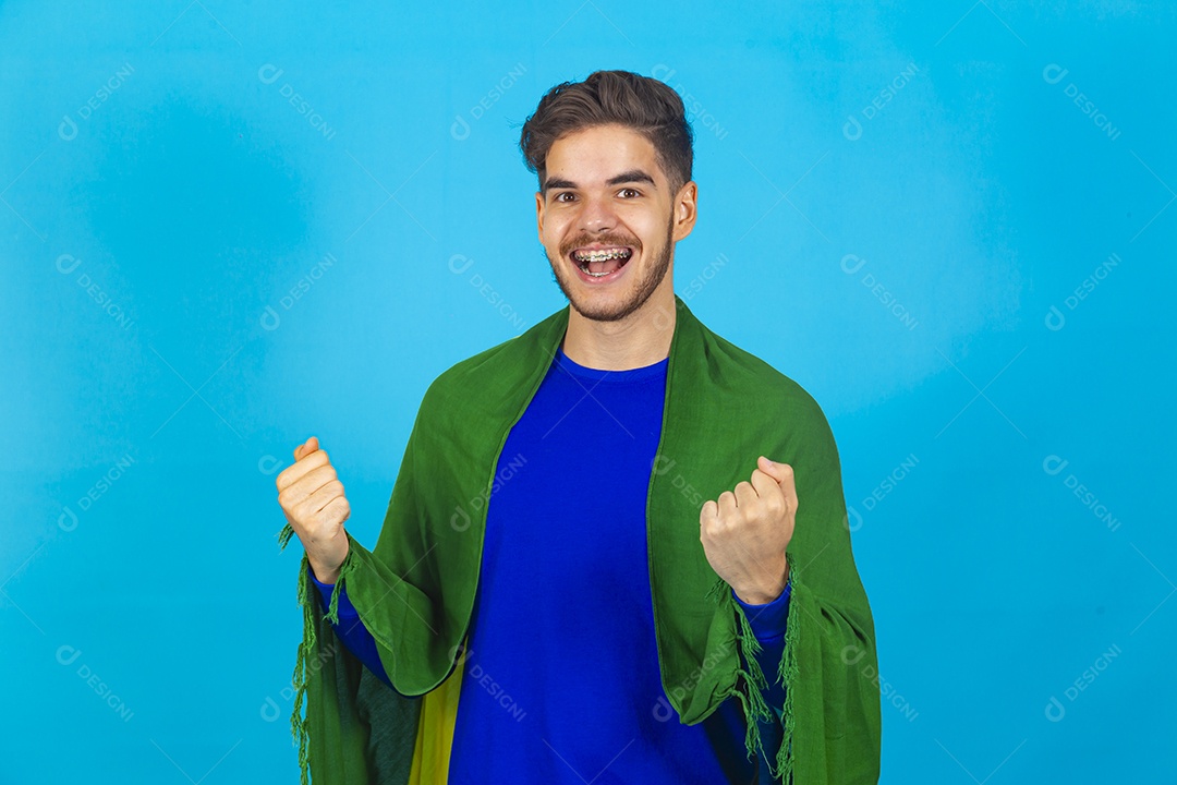 Homem segurando bandeira do Brasil sobre um fundo isolado azul.