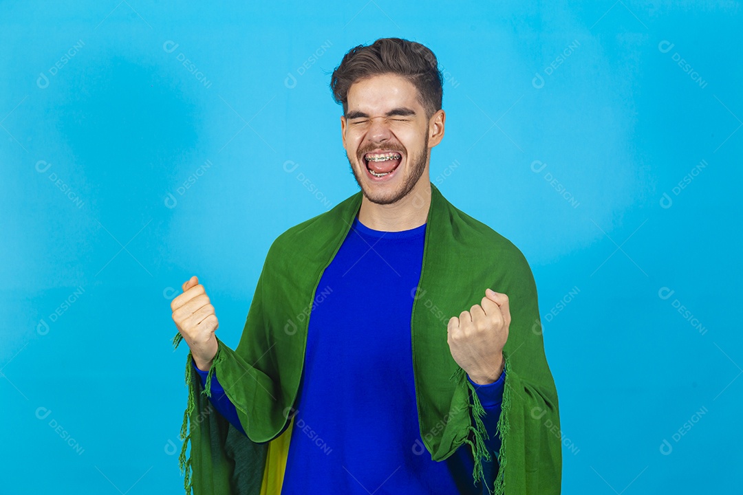 Homem segurando bandeira do Brasil sobre um fundo isolado azul.
