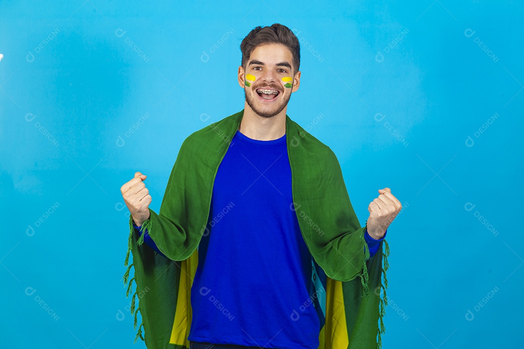 Homem segurando bandeira do Brasil sobre um fundo isolado azul.