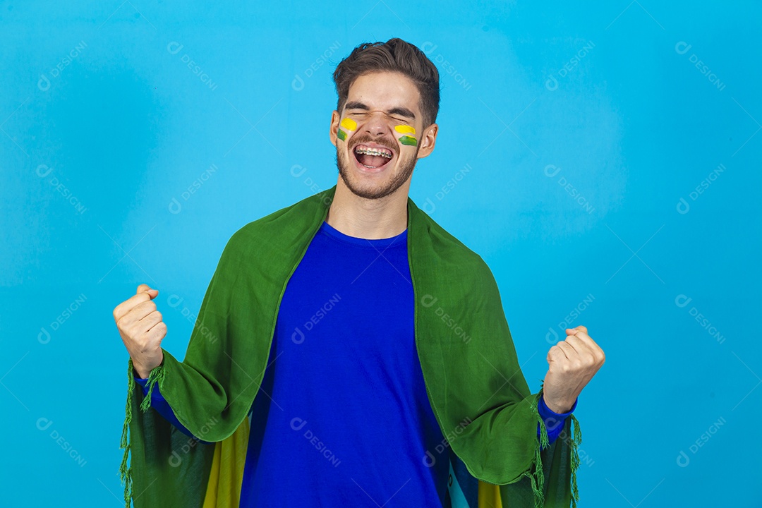 Homem segurando bandeira do Brasil sobre um fundo isolado azul.