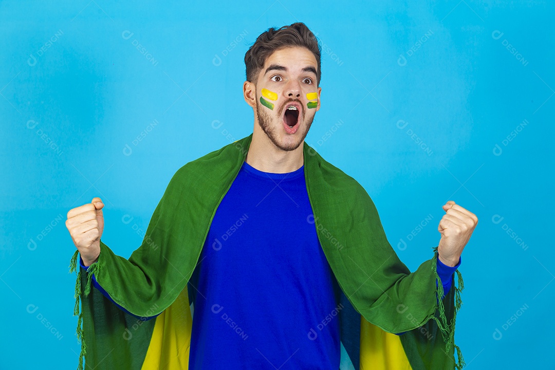 Homem comemorando com bandeira do Brasil nas costas sobre fundo isolado azul.
