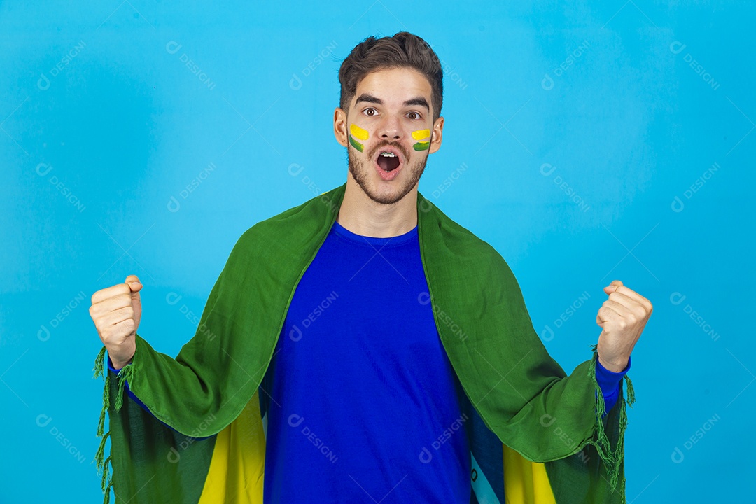 Homem comemorando com bandeira do Brasil nas costas sobre fundo isolado azul.