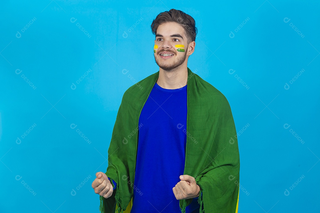 Homem segurando bandeira do Brasil sobre um fundo isolado azul.