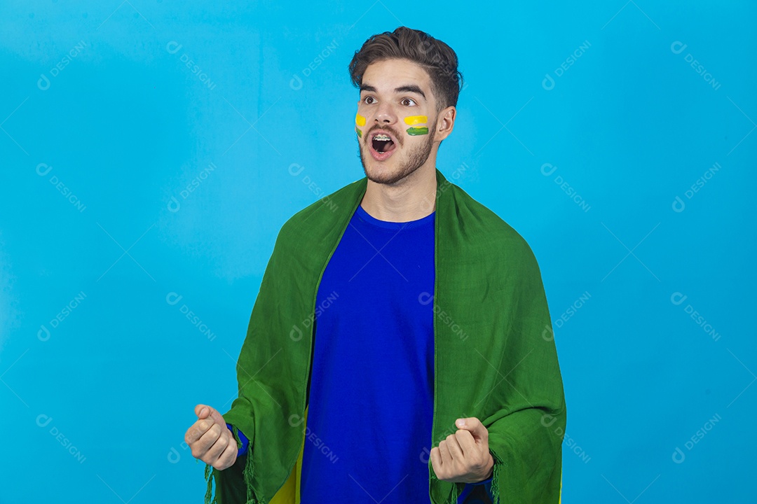 Homem comemorando com bandeira do Brasil nas costas sobre fundo isolado azul.