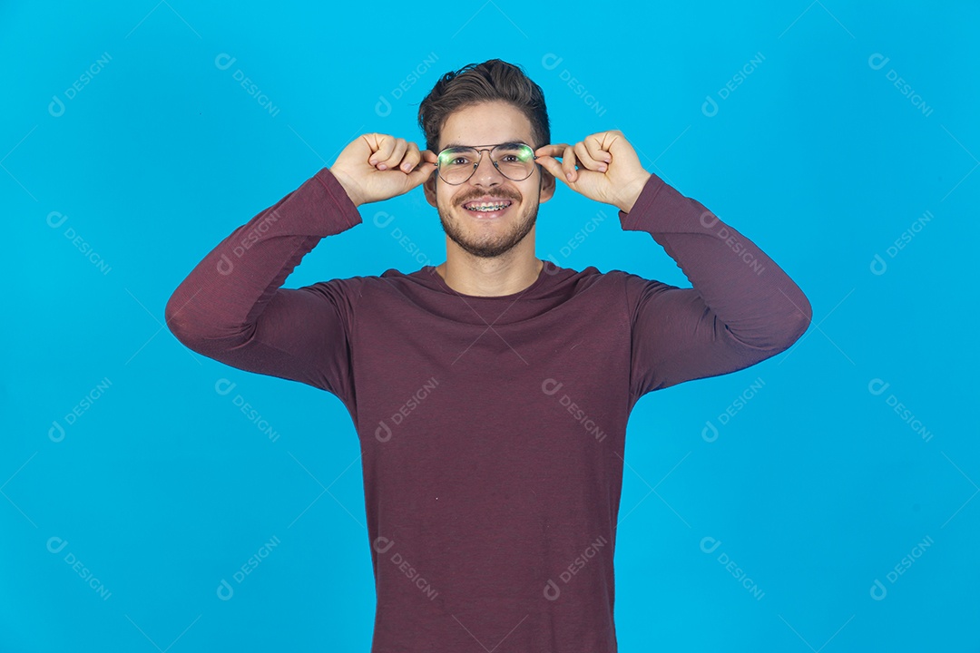 Homem sorridente usando óculos sobre um fundo isolado azul.