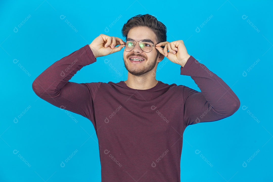 Homem sorridente usando óculos sobre um fundo isolado azul.