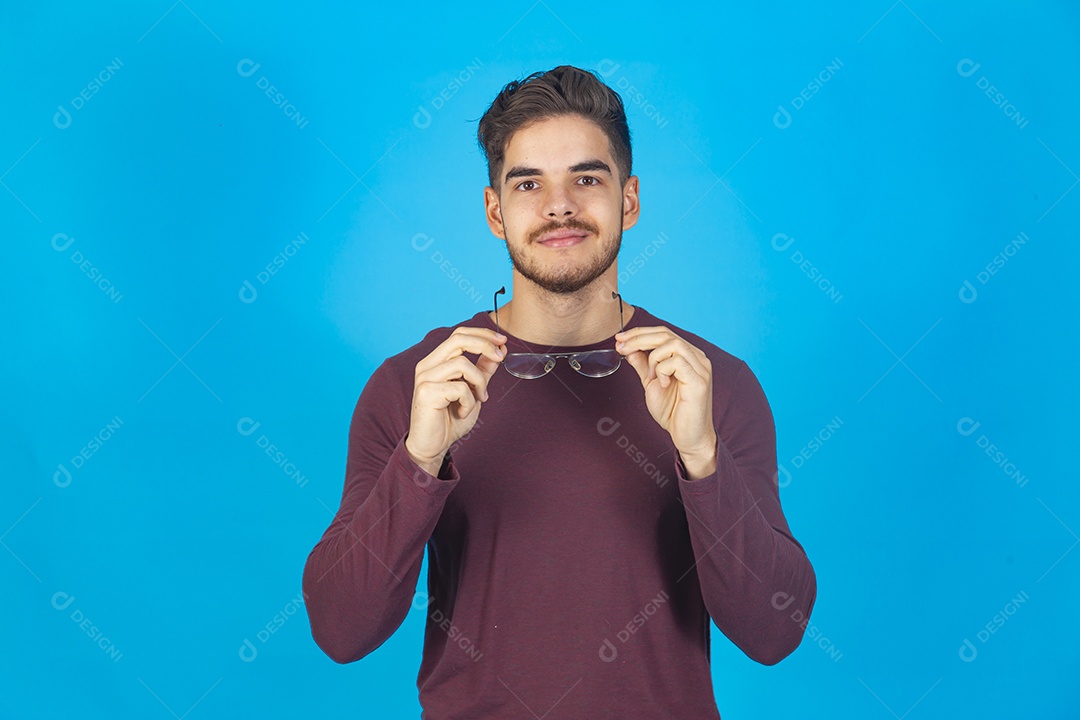 Homem sorridente usando óculos sobre um fundo isolado azul.