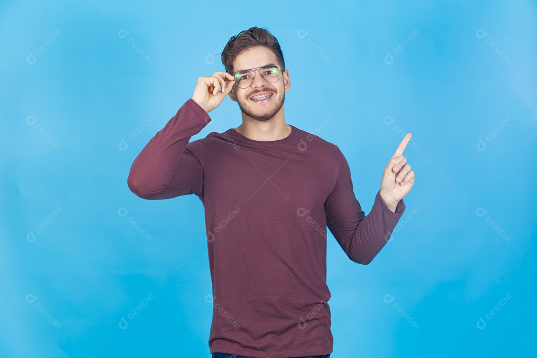 Homem sorridente usando óculos sobre um fundo isolado azul.